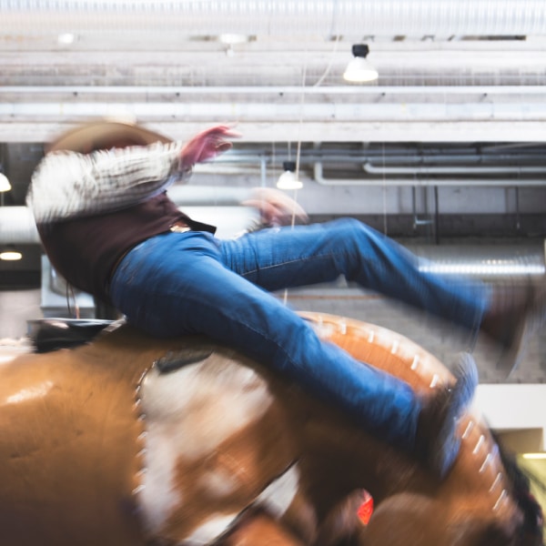 Cowbow participant riding a crazy mechanical bull