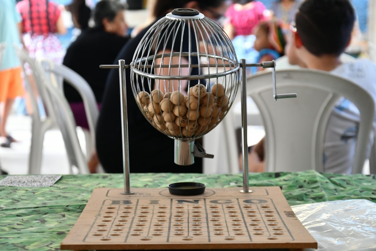 Close-up of a bingo cage with numbered balls and board, ready for play.